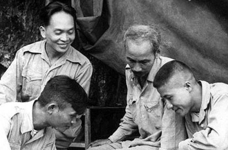 Trong ảnh là Chủ tịch Hồ Chí Minh cùng Đại tướng Võ Nguyên Giáp và Trung đoàn trưởng Thái Dũng (hàng dưới, bên trái ảnh), Tiểu đoàn trưởng Dũng Mã (bên phải) nghiên cứu sơ đồ tác chiến Chiến dịch biên giới 1950.