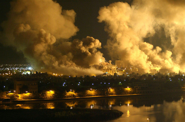 Khói bao trùm khu dinh thự Tổng thống ở Baghdad, ngày 21/3/2003, trong cuộc không kích quy mô lớn do Mỹ dẫn đầu vào thủ đô Iraq. Phóng viên AFP cho biết khói bốc lên từ một số địa điểm được nhắm mục tiêu, bao gồm cả một trong những cung điện của Tổng thống Saddm Hussein. (Ảnh: Ramzi Haidar/AFP/Getty Images).
